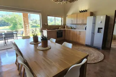 a kitchen with a wooden table and a refrigerator at Riverbank in Tulbagh