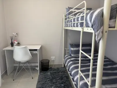 a bedroom with a bunk bed and a desk at Modern 3 bedroom Urban Getaway in Cape Town