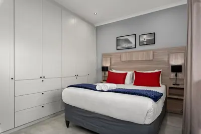 a bedroom with a large bed with red pillows at Tafelzicht Peaceful Retreat - Wifi - Netflix in Cape Town
