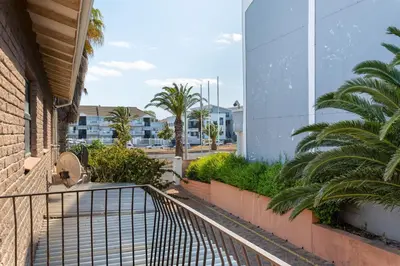 a balcony with palm trees and a building at Tafelzicht Peaceful Retreat - Wifi - Netflix in Cape Town