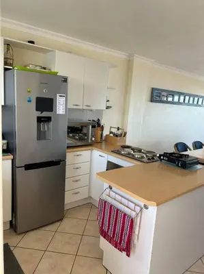a kitchen with a stainless steel refrigerator and a counter at Nautica by the Beach in Cape Town