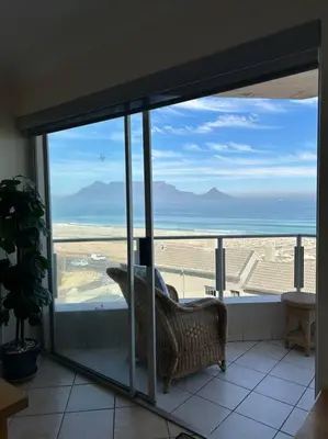 a room with a view of the ocean from a window at Nautica by the Beach in Cape Town