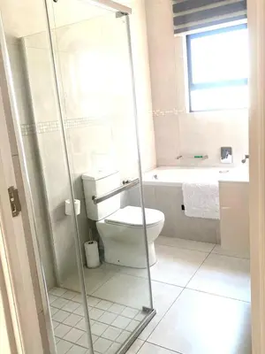 a bathroom with a toilet and a glass shower at Five bedrooms holiday home in Cape Town