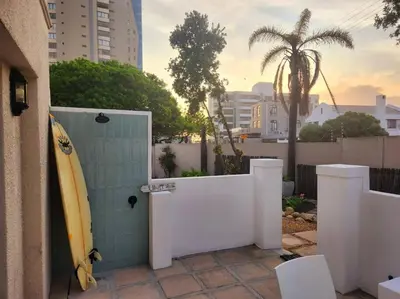 a surfboard leaning against a wall next to a door with a surfboard at No 4 Life at Sea in Strand
