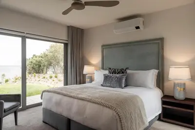 a bedroom with a large bed and a large window at Azure Retreat in Hermanus