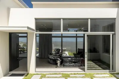 a house with large glass windows and a living room at Azure Retreat in Hermanus
