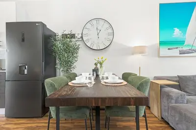 a dining room with a table and a clock on the wall at Atlantic Port 10 by Host Agents in Cape Town