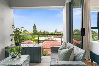 a balcony with a chair and a table with a view at Atlantic Port 10 by Host Agents in Cape Town
