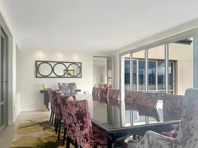 a dining room with a glass table and chairs at Oceanique in Hermanus