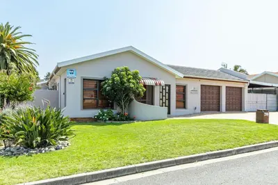 a house with a green lawn in front of it at House of joy in Cape Town