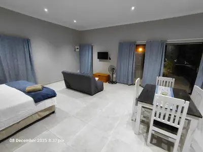 a bedroom with a bed and a desk and a chair at House of joy in Cape Town