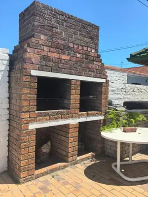 an outdoor brick pizza oven on a patio at Pinelands guesthouse in Cape Town