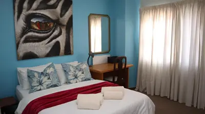 a bedroom with a bed with two towels on it at Strand Beach Townhouse Self Catering in Cape Town