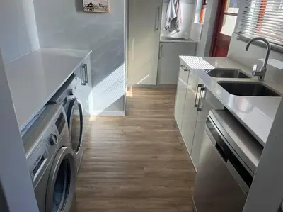 a kitchen with a washer and a sink and a washing machine at Divine View in Cape Town