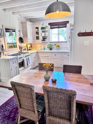 a kitchen with a large wooden table and chairs at Garden oasis in the village in Franschhoek
