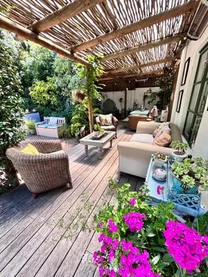 a patio with a couch and chairs and flowers at Garden oasis in the village in Franschhoek