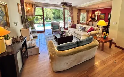 a living room with a couch and a table at Garden oasis in the village in Franschhoek