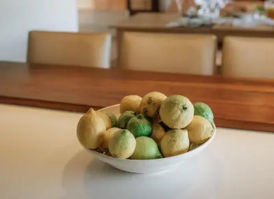 a bowl of fruit sitting on a table at 13 Olives, Entire Grape & Olive Estate, Somerset West by Euphoric Leisure in Sir Lowryʼs Pass