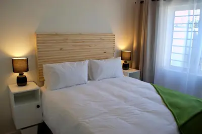 a bedroom with a large white bed with two lamps at Camden Stay - Entire Unit - Cape Town in Cape Town