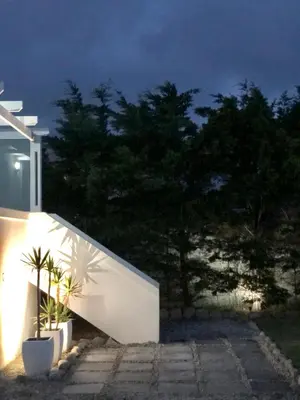 a white building with two potted plants on the side at #SilverSands Coastal Retreat in Betty's Bay in Bettyʼs Bay