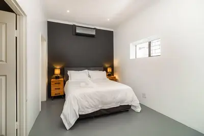 a bedroom with a white bed and a window at 1Bed Flat, Braai, AC, Walking Distance from Blouberg Beachfront in Cape Town