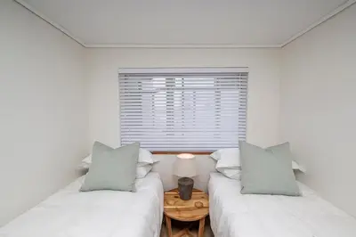 two beds in a room with a window at 2 Bedroom Apartment - Blouberg Beachfront in Cape Town
