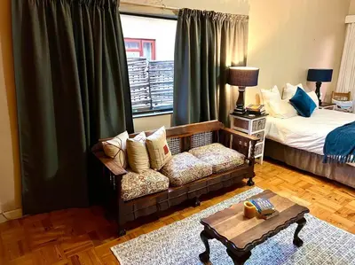 a living room with a couch and a bed at Cosy Home with an Ocean Breath! in Cape Town