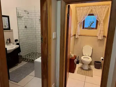 a bathroom with a toilet and a shower and a sink at Cosy Home with an Ocean Breath! in Cape Town