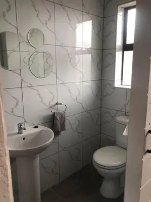 a white bathroom with a toilet and a sink at Entire Spacious Guest suite in Cape Town in Cape Town