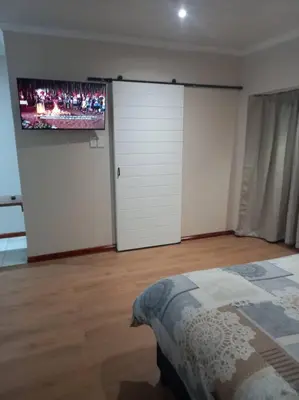 a bedroom with two white doors and a tv on the wall at Entire Spacious Guest suite in Cape Town in Cape Town