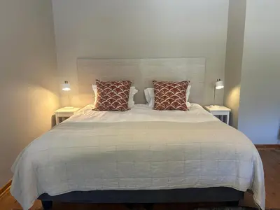 a bedroom with a large white bed with pillows at Eight on Tuin in Franschhoek
