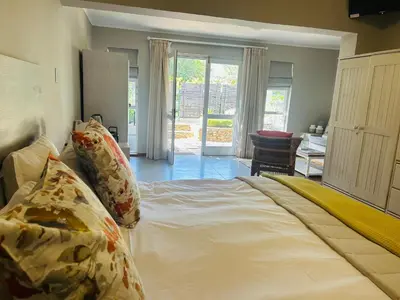 a bedroom with a large bed with pillows on it at Eight on Tuin in Franschhoek