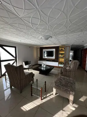 a living room with a coffered ceiling and two chairs at Luxurious 4 bedroom Family Home in Cape Town