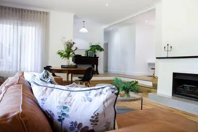 a living room with a couch and a fireplace at Luxury Poolside Villa Irene in Cape Town