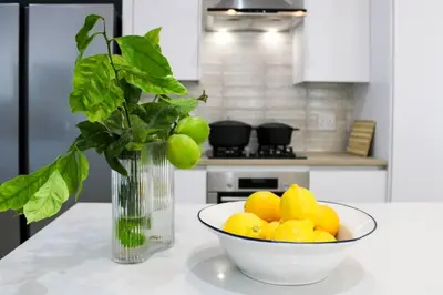 a vase of lemons and a bowl of fruit on a kitchen counter at Luxury Poolside Villa Irene in Cape Town