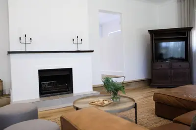 a living room with a fireplace and a tv at Luxury Poolside Villa Irene in Cape Town