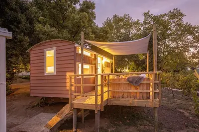 a tiny house with a porch and a canopy at The Huts - Glamping at Caledon Grace in Caledon