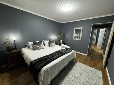 a bedroom with a large bed and a blue wall at Ocean Breath Apartment in Strand