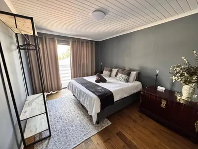 a bedroom with a large bed and a mirror at Ocean Breath Apartment in Strand