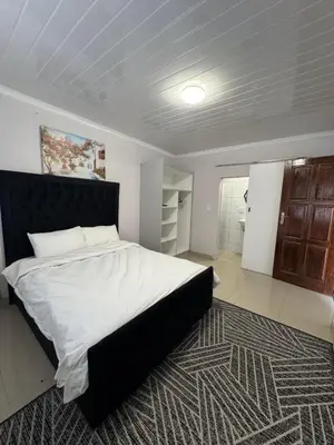 a bedroom with a large white bed and a rug at Canary Guest house in Cape Town