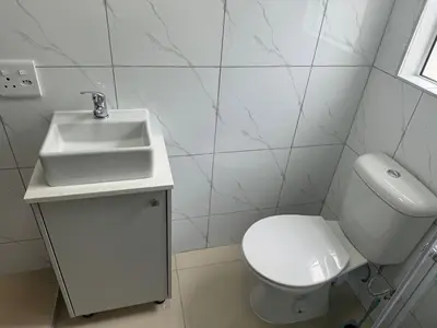 a white bathroom with a sink and a toilet at Canary Guest house in Cape Town
