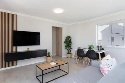 a living room with a couch and a table at Elegant apartment near beach in Cape Town