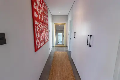 a hallway with white walls and a rug on the floor at Waveren's Nest in Cape Town