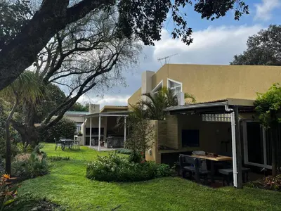 a house with a yard with a table at Voëlklip Holiday Home in Hermanus