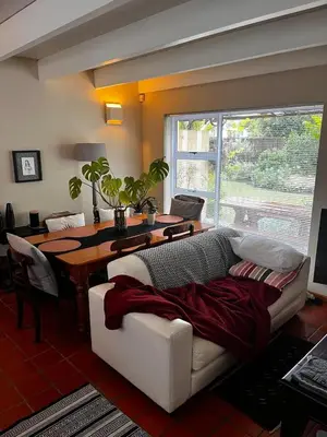 a living room with a couch and a table with a laptop at Voëlklip Holiday Home in Hermanus