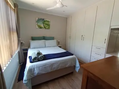 a bedroom with a bed and a dresser at 45 on Luke in Hermanus