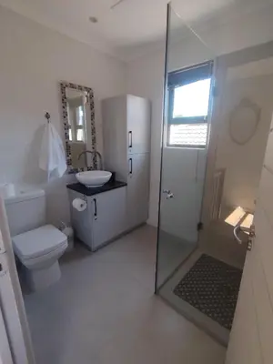 a bathroom with a toilet and a sink and a shower at 45 on Luke in Hermanus
