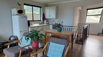 a kitchen with a table and chairs and a refrigerator at 45 on Luke in Hermanus