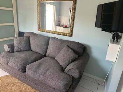 a couch in a living room with a mirror at Casa on Alamein in Cape Town