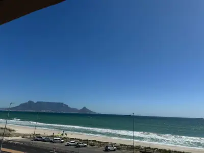 a view of the beach and the ocean with cars parked at BEACHFRONT Breeze in Cape Town